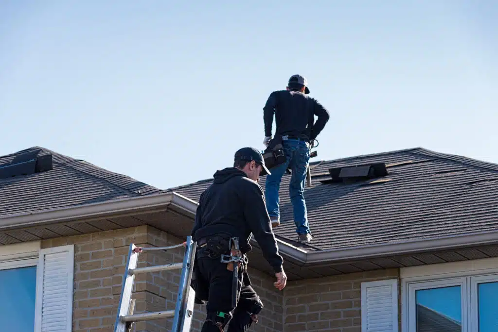 Two,Roofers,Inspecting,A,Damaged,Roof.