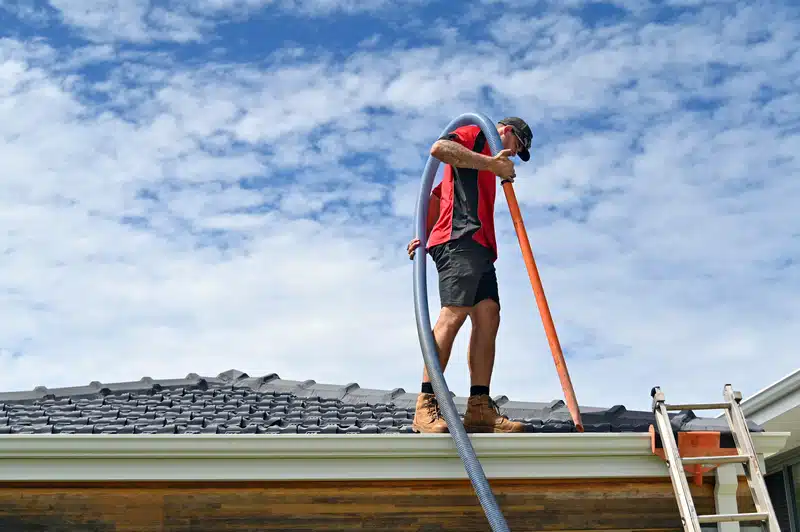 man doing inspection at the roof for gutter maintenance