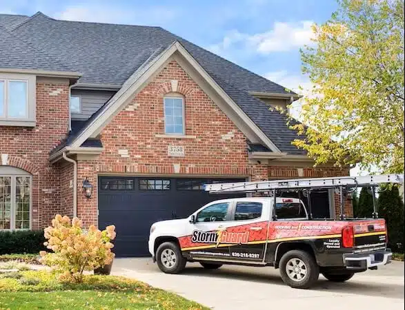 Brick House with Storm Guard Restoration Services Truck In Driveway - Dupage