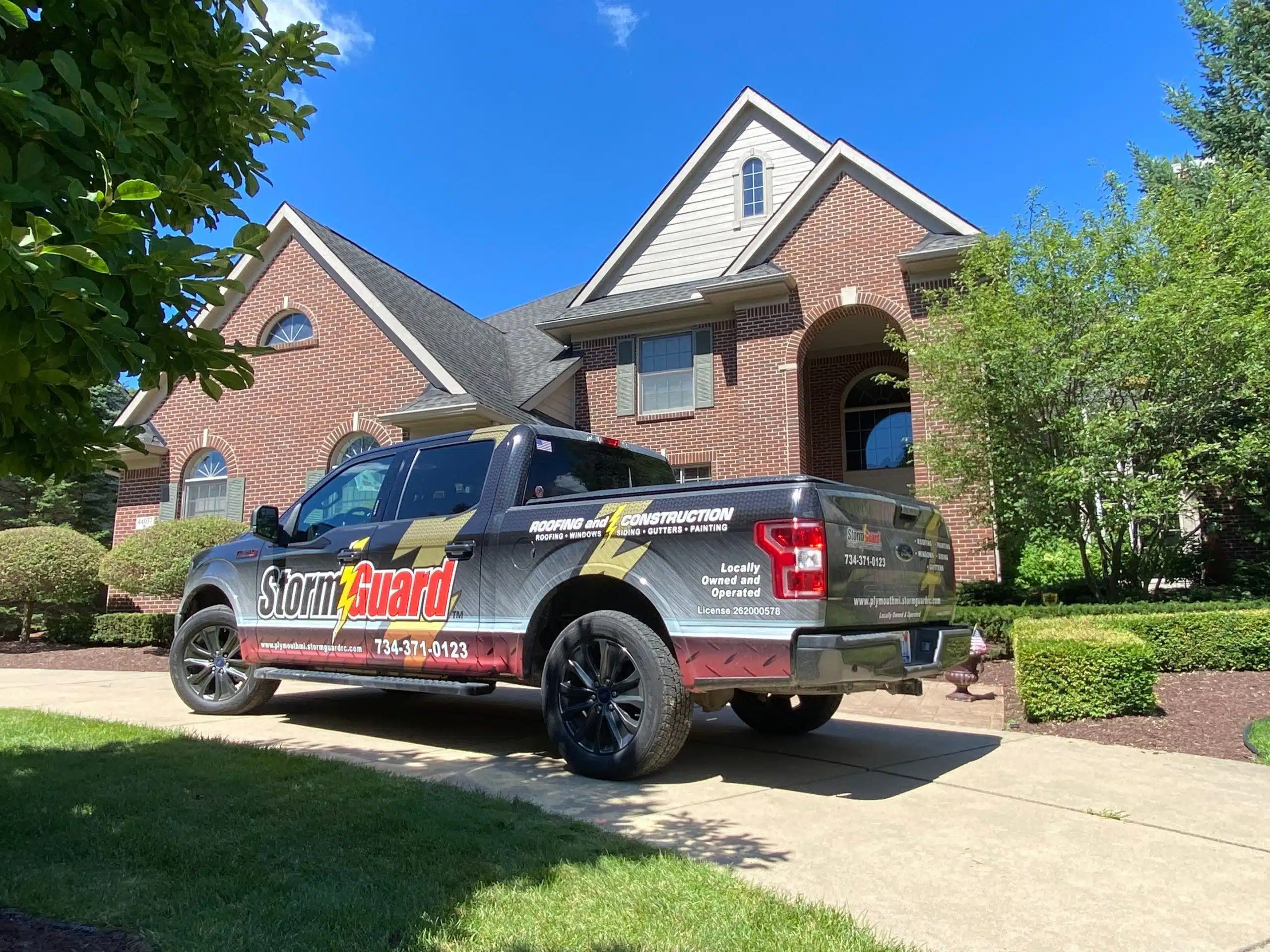 Brick House with Storm Guard Restoration Services Truck In Driveway - Plymouth