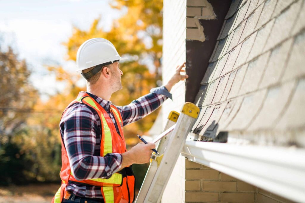 A roof inspector inspecting the roof of the house